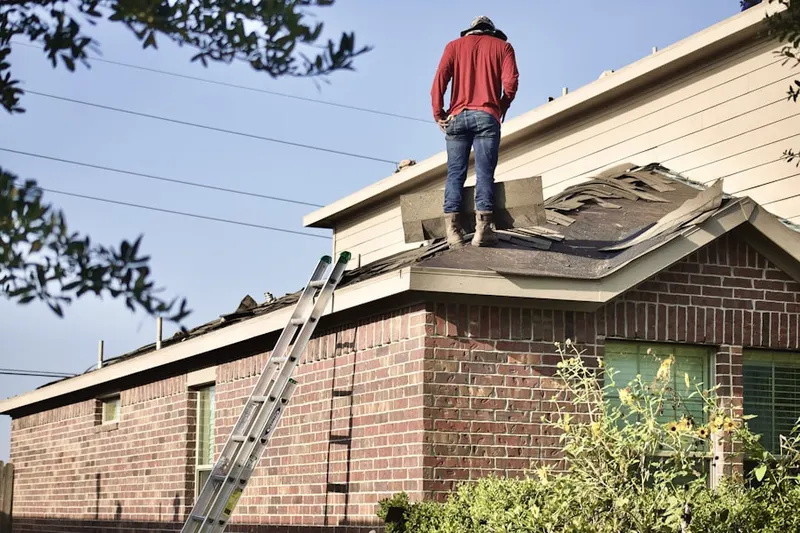 Professional roofer working on a residential roof in Bellaire Gardens